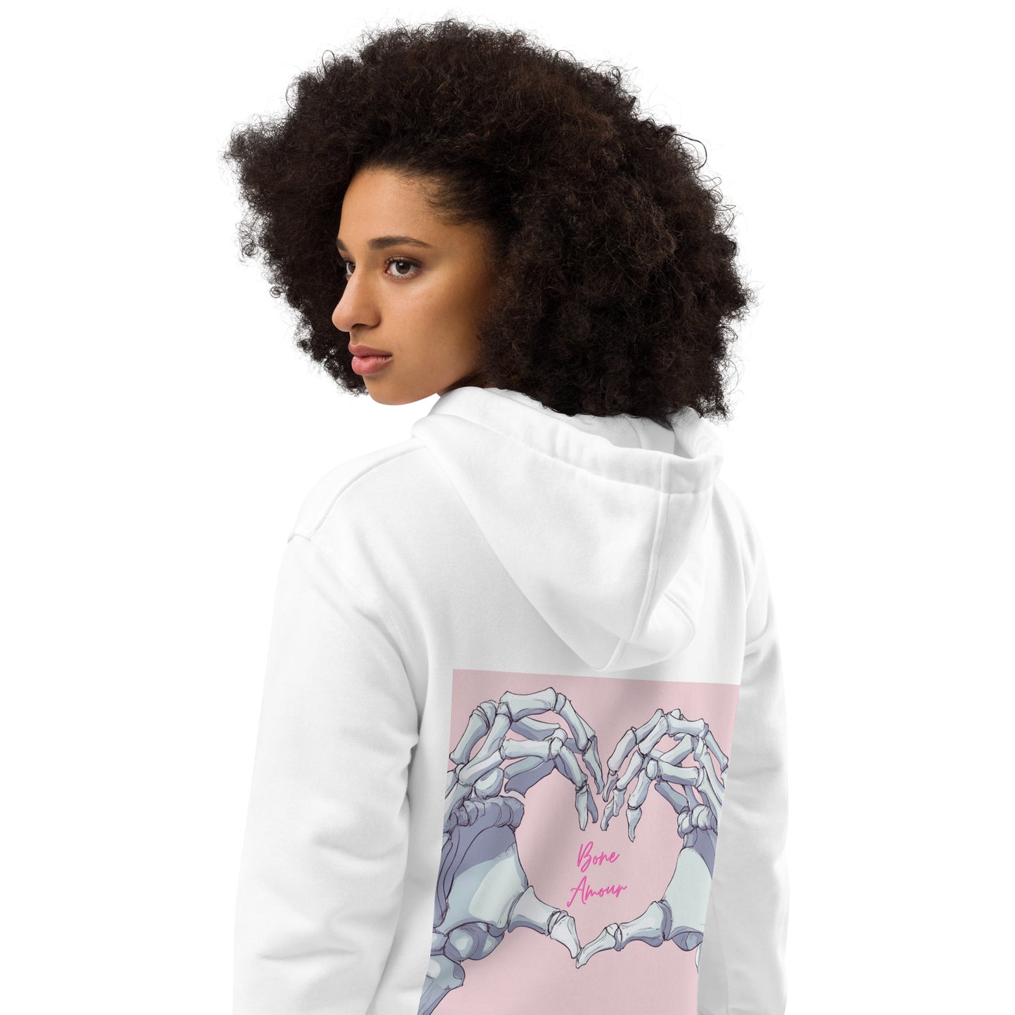 Seitliche Ansicht des Bone Amour Hoodies, getragen von einer Frau – weißer Kapuzenpulli mit rosa Schrift, Herz- und Skelettdesign.
