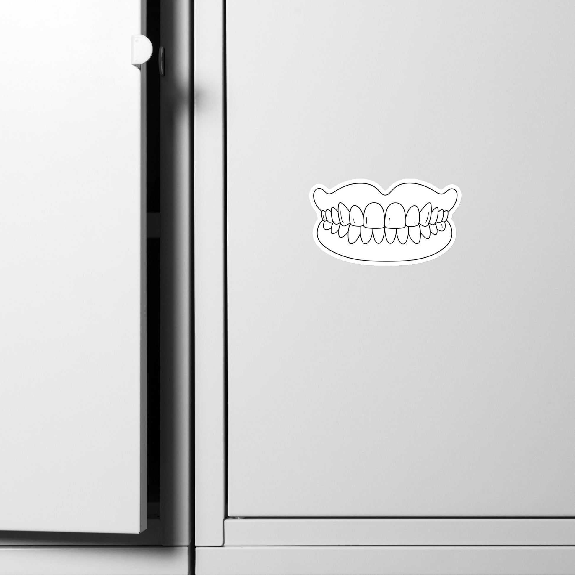 Minimalistischer Magnet mit Totalprothesen-Motiv in Schwarz-Weiß auf silberner Oberfläche – humorvolles Dental-Accessoire für Kühlschrank, Spind oder Praxis