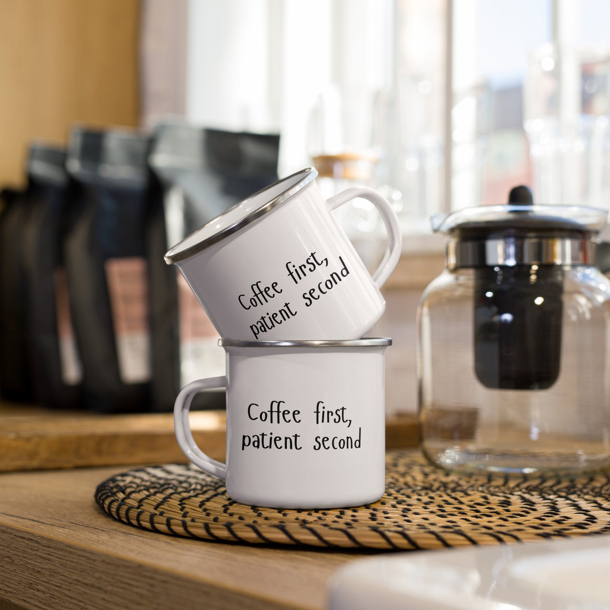 Weiße Emailletasse mit schwarzem Schriftzug „Coffee first, patient second“ – humorvolle Tasse für Medizin, Zahnmedizin, Klinik und Praxisalltag
