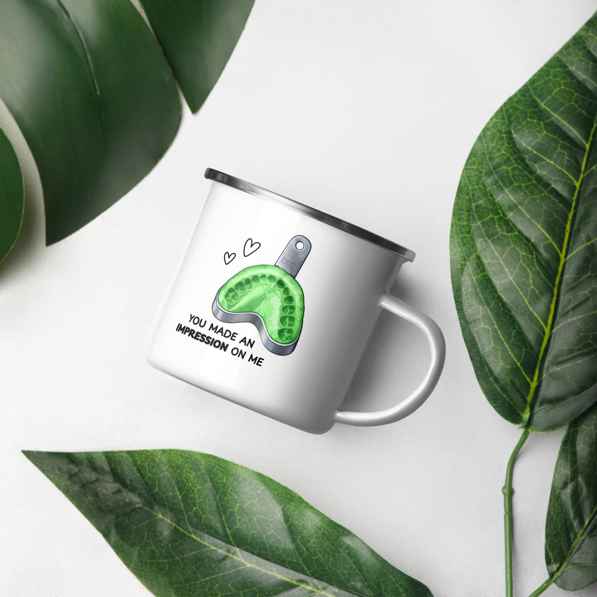 Weiße Emailletasse mit grünem Zahnabdruck/Abdrucklöffel-Motiv und Schriftzug „You made an impression on me“ – humorvolle Dental-Tasse für Zahnmedizin und Kieferorthopädie