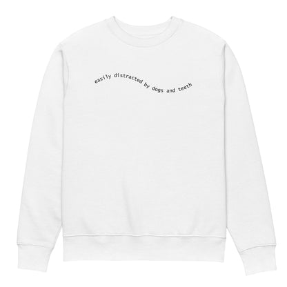 Weißer Unisex Bio-Pullover mit minimalistischer schwarzer Schrift „easily distracted by dogs and teeth“ auf der Brust – gemütlicher Sweater für Hunde- und Zahnmedizin-Fans