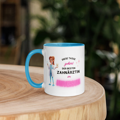 Weiße Keramiktasse mit farbigem Henkel und Innenseite sowie Motiv „Diese Tasse gehört der besten Zahnärztin im Universum“ – Geschenkidee für Zahnärztinnen